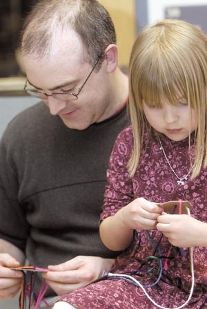 A father and daughter braiding together on cards